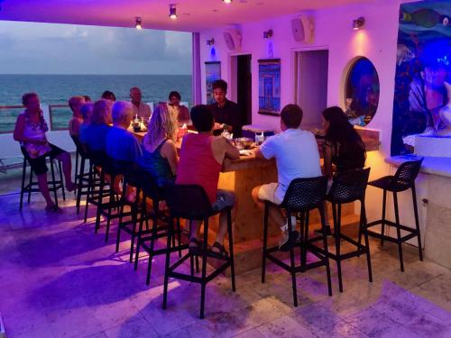 
people sitting at tables in a restaurant at Casa Sirena Hotel Isla Mujeres in Isla Mujeres
