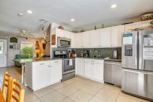 a kitchen with white cabinets and stainless steel appliances at Beachfront Ocean Duplex in Layton