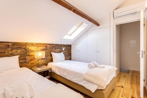 a bedroom with two beds and a lamp on a table at Hopstays Oporto Tiles 2 - City Center Duplex in Porto