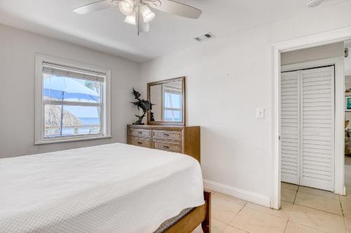 a bedroom with a bed and a mirror and a window at Beachfront Ocean Duplex in Layton