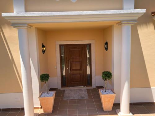 a front door of a house with two potted plants at Villa Mar Azul in Albufeira