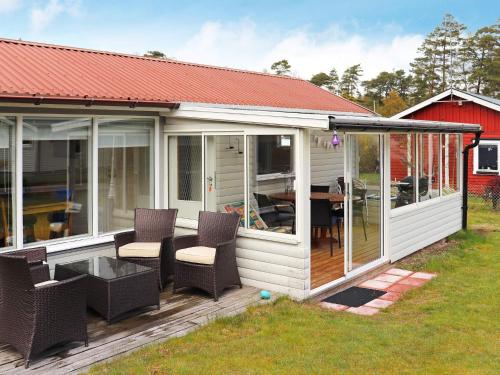 Casa blanca con terraza con sillas y mesa en 5 person holiday home in MELLBYSTRAND en Mellbystrand