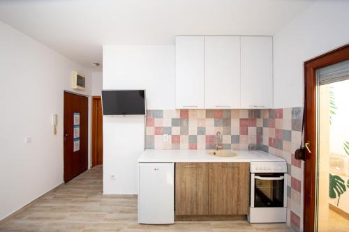 - une cuisine avec des placards blancs et un évier dans l'établissement Budva Apartment Nadja, à Budva