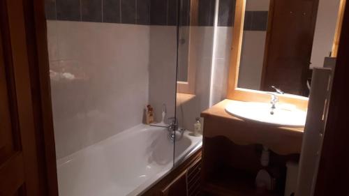 een badkamer met een wit bad en een wastafel bij Appartement Valmeinier 4 à 5 personnes Résidence LAGRANGE in Valmeinier