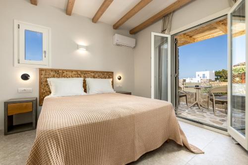 a bedroom with a bed and a balcony at Sea & Sun Paros in Naousa