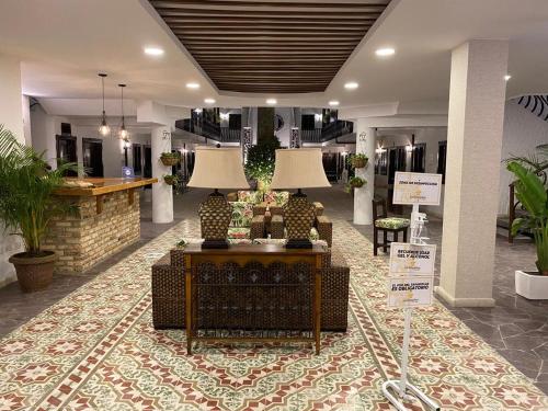 a lobby with a couch and two lamps in it at Casa Hotel Las Orquideas in Circasia