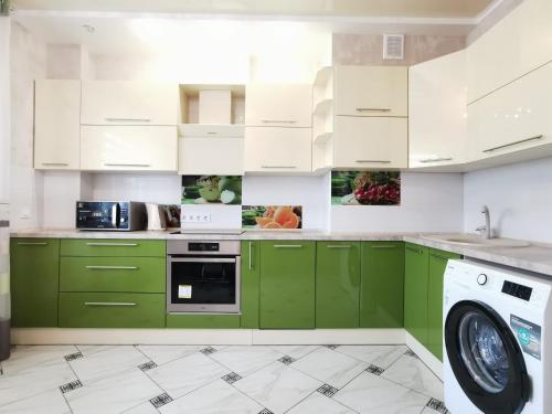 cocina con armarios verdes y lavavajillas en Manufactura luxery apartments en Sumy