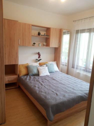a bedroom with a large bed with blue sheets at Rozmaring Apartman Zánka in Zánka
