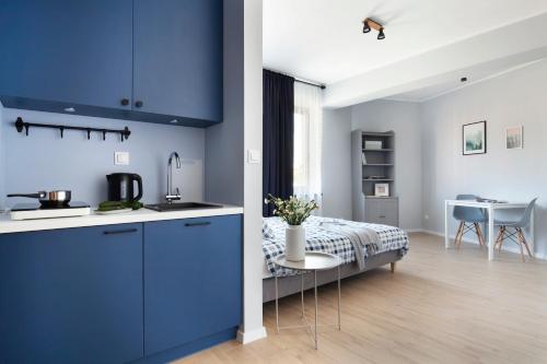 eine Küche mit blauen Schränken und ein Bett in einem Zimmer in der Unterkunft WOLNE CHWILE in Osiek