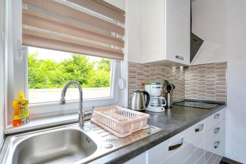 eine Küchentheke mit Spüle und Fenster in der Unterkunft Apartments Laguna in Nin