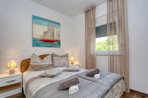 ein Schlafzimmer mit einem Bett mit einem Segelboot darauf in der Unterkunft Apartments Laguna in Nin