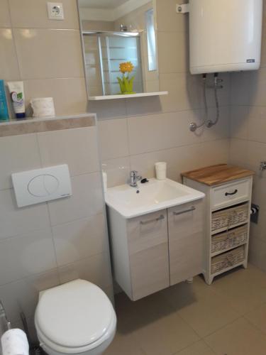 a bathroom with a white toilet and a sink at Smokvica in Split
