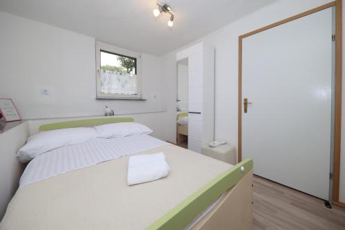 1 dormitorio con 1 cama blanca grande y cabecero verde en Country House Korlat en Benkovac