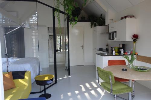 een keuken en een woonkamer met een tafel en stoelen bij B&B Achterom in Loon op Zand