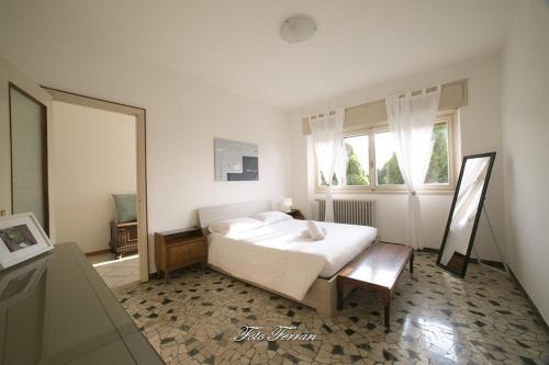 Habitación blanca con cama y ventana en CASA VACANZE GLI ULIVI DEL LAGO, en Sale Marasino