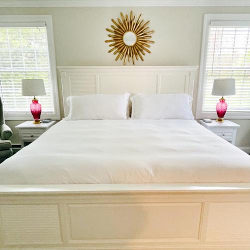 a bedroom with a large white bed with two lamps at The Homestead in Madison