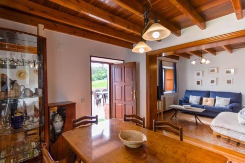 - un salon avec une table et un canapé dans l'établissement Cómoda casa en entorno natural y cerca de la playa, à Somo