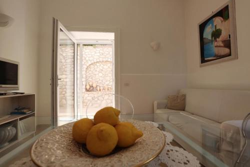 a living room with a table with fruit on it at Casa di charme panoramica a Capri sulla spiaggia. in Capri