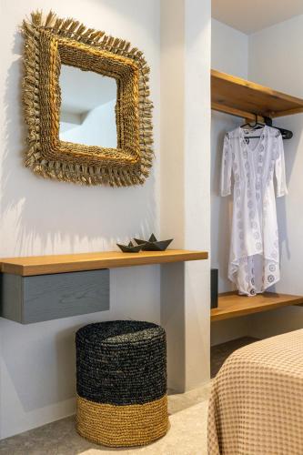 a mirror hanging on a wall next to a bedroom at Sea & Sun Paros in Naousa
