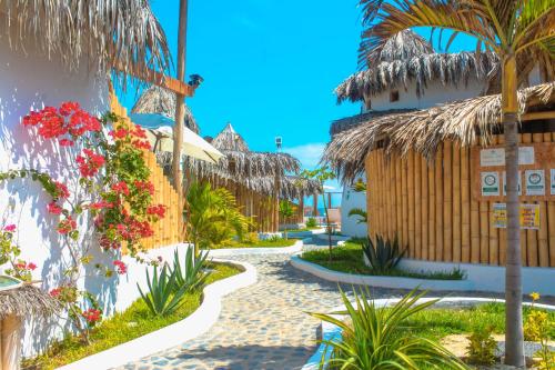 a walkway through the resort with flowers and plants at Maracol Bungalows Vichayito in Vichayito