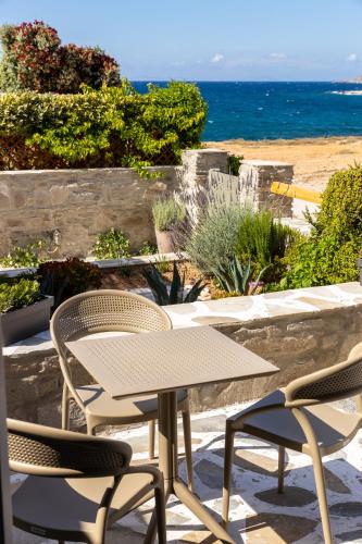 a table and chairs on a patio overlooking the ocean at Sea & Sun Paros in Naousa