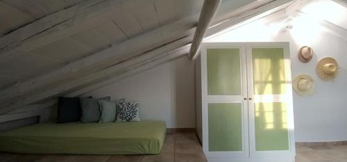Cette chambre mansardée comprend un lit vert. dans l'établissement Paperboat apartment, à Afytos