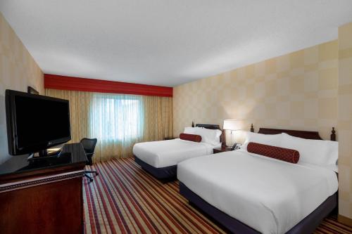 a hotel room with two beds and a flat screen tv at Wyndham Grand Oklahoma City Downtown in Oklahoma City