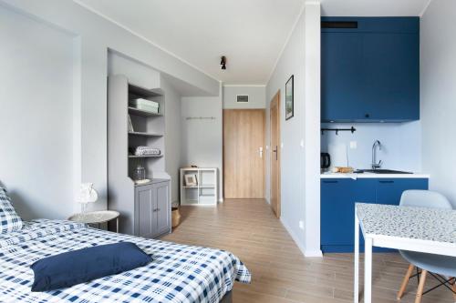 a bedroom with a blue and white bed and a kitchen at WOLNE CHWILE in Osiek
