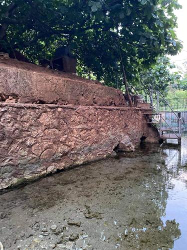 a brick wall next to a body of water at Bujtina Gjyshi Ilo in Pogradec