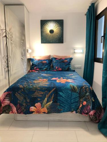 a bedroom with a bed with a blue comforter at Bungalow Atos With Private Garden in Playa del Ingles