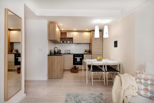a kitchen and dining room with a table in a room at W&K Apartments - Compact II in Koszalin