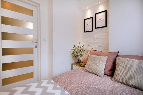 a bedroom with a bed and a wall with stripes at W&K Apartments - Compact II in Koszalin