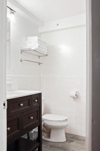 a white bathroom with a toilet and a sink at The Beverly in Beverly