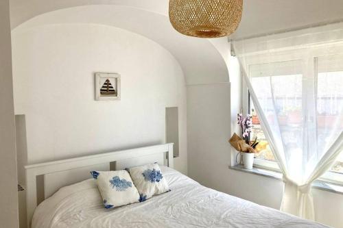 a bedroom with a bed with a window and a pillow at Casa Martulè (vista mare) - Marina Piccola, Capri in Capri