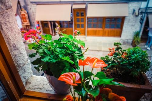 a window sill with flowers and a toy house at Medieval Rooms in Gjirokastër