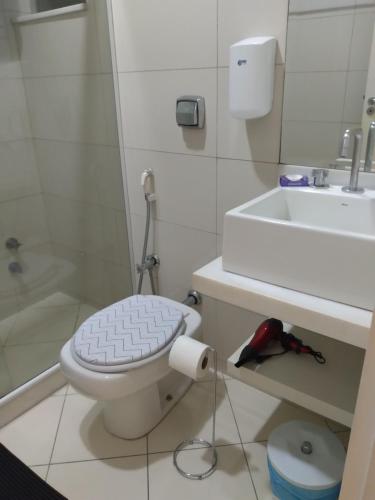 a white bathroom with a toilet and a sink at Copacabana Beach Modern Apartments in Rio de Janeiro