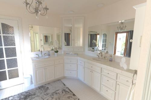 Baño blanco con 2 lavabos y espejos en Cozy mountain retreat with lake views near Yosemite, en Groveland