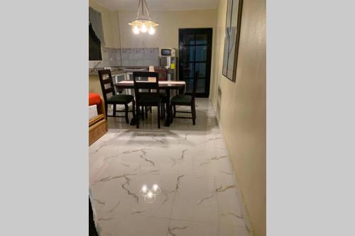 um corredor com piso em mármore branco, uma mesa e cadeiras em Céntrico para 2 personas con tv marquesina luz y cocina em La Romana