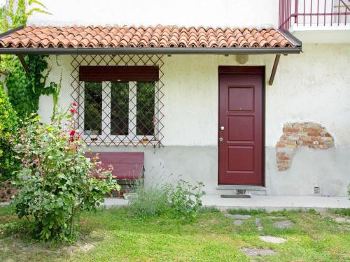 a red door on the side of a white house at Holiday home in Asti with a lovely hill view from the garden in Moncucco Torinese