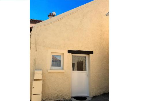 - un bâtiment avec une porte blanche et une fenêtre dans l'établissement Charmante Maison Cosy à Villabé-Hyper Centre-Gare-WIFI, à Villabé