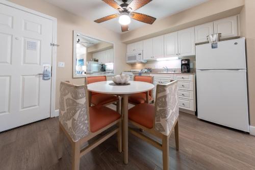 a kitchen with a table and chairs and a refrigerator at Southern California Beach Club in Oceanside