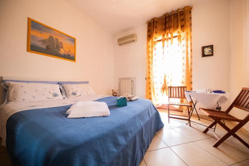 1 dormitorio con 1 cama azul, mesa y sillas en ANFOL, en Bari