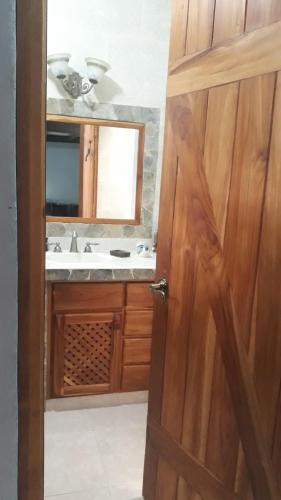 a bathroom with a sink and a wooden door at Valle Luna in Valle de Anton