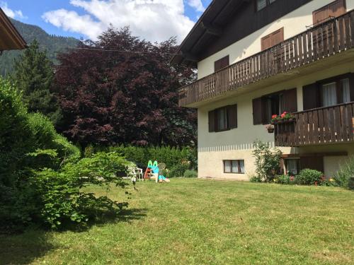 un cortile di fronte a un edificio con parco giochi di Villa Verde B&B a Pinzolo