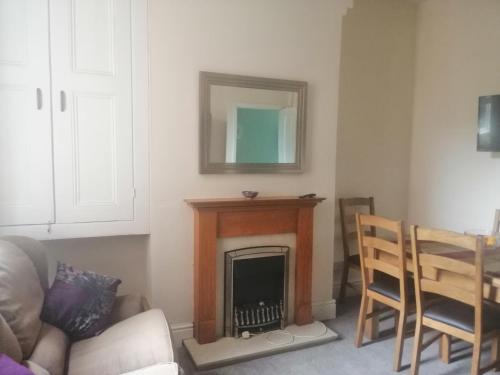 a living room with a fireplace and a table and chairs at Ripon Street Lincoln in Lincoln
