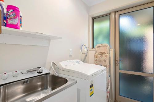 eine kleine Küche mit einem Waschbecken und einem Fenster in der Unterkunft Casa Bella - Nelson Holiday Home in Nelson