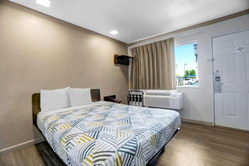 a hotel room with a bed and a window at Motel 6-Red Bluff, CA in Red Bluff