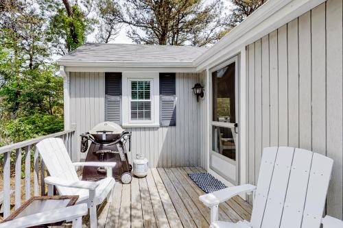 a deck with two chairs and a grill on it at Whitman Surf Cottage & Great Hollow Retreat in Truro