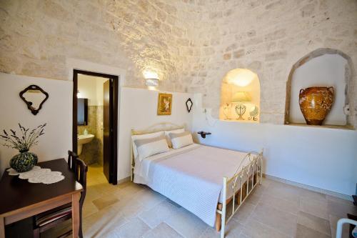 ein Schlafzimmer in einer Villa mit einem Bett und einem Bad in der Unterkunft B&B Masseria Nuove Caselle in Villa Castelli