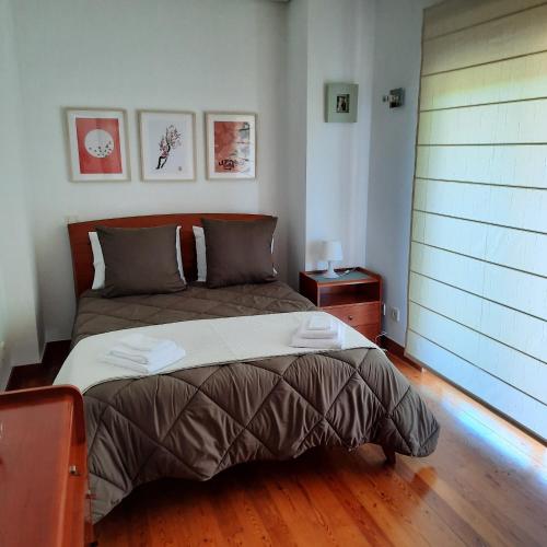 1 dormitorio con 1 cama y suelo de madera en Casa da Escola, en Tabuaças